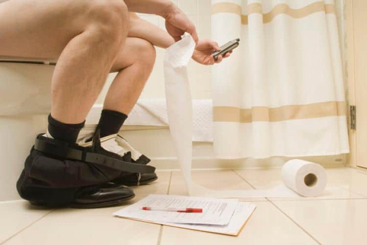 man using phone in the toilet