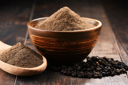 black pepper, a spoon and cup of black pepper powder
