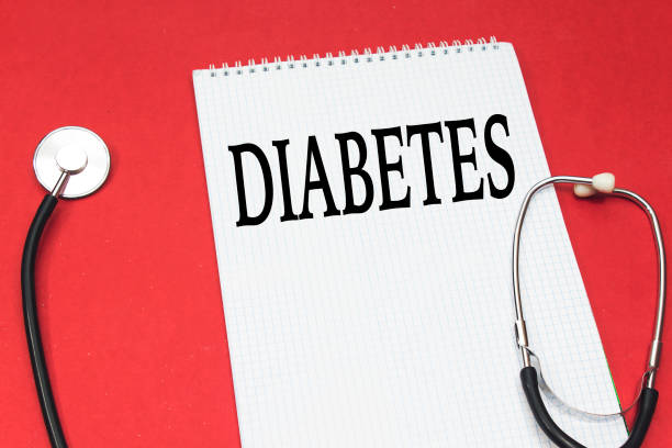 Diabetes-001-01-1 disease diabetes concept handwriting on white notebook and stethoscope on red background