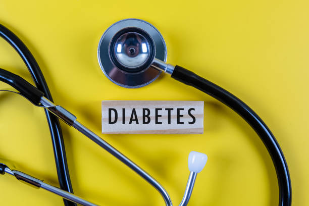 Diabetes-001-02-1 The word Diabetes is written on wooden blocks and stethoscope on yellow background.