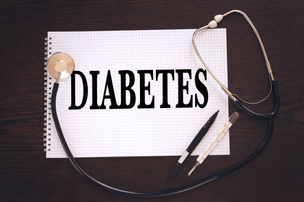 disease diabetes concept handwriting on white notebook and stethoscope, thermometer on wood table
