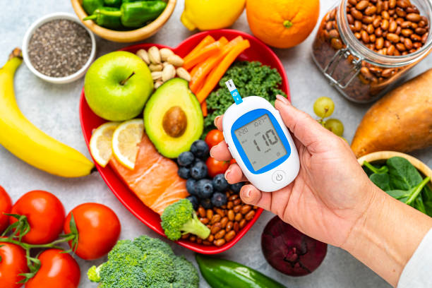 Hand holding glucometer on healthy food background.