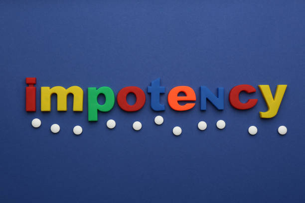 Word IMPOTENCY and pills on blue background, flat lay