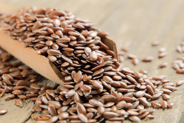 Flax seed macro in wooden spoon and on wooden table
