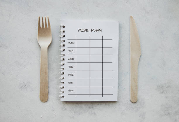 Ring binder, fork and knife on the white background.