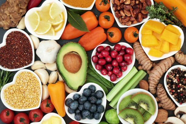 Health food for fitness concept with fresh fruit, vegetables, pulses, herbs, spices, nuts, grains and pulses. High in anthocyanins, antioxidants,smart carbohydrates, omega 3 fatty acids, minerals and vitamins.