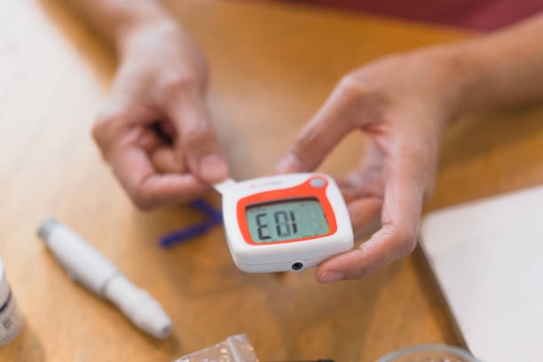 young woman using blood test kit at home while doing health check . home finger prick blood test . close up, diabetes concept, elderly health care,