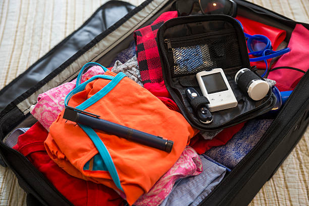 A suitcase with diabetes medical test devices on a bed. Travelling with diabetes.