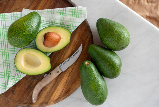 Cut avocado on the brown wooden board in the kitchen