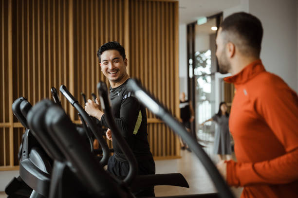 White people working out in gym with his Asian friend