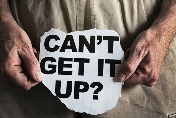Man's hands hold a torn-out newspaper headline asking an awkward question about erectile dysfunction.