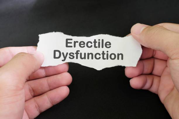 Erectile dysfunction diagnosis and anxiety concept. Male hand holding paper with written word text in black background.