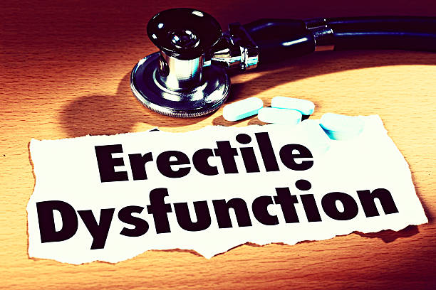 A press headline on erectile dysfunction with a stethoscope, and some little blue pills, all resting on a wooden desk.