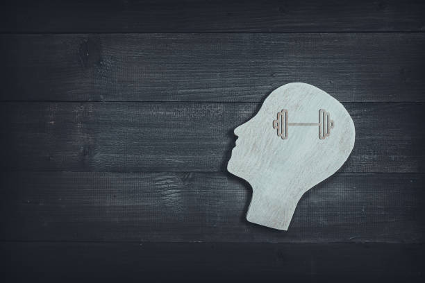 Human head and face with barbell sign on wood table background. Brain of thinking about health , Symbol of Process and Positive Mind concept