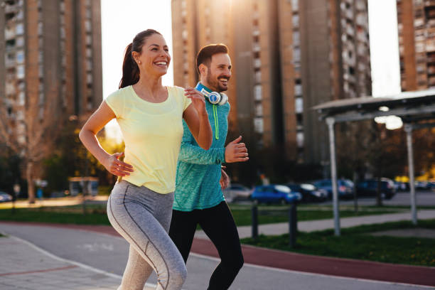Young attractive and cheerful couple running outside on sunny day