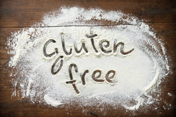 Baking background with flour on wooden table. Text Gluten free is handwritten in flour. Healthy eating concept