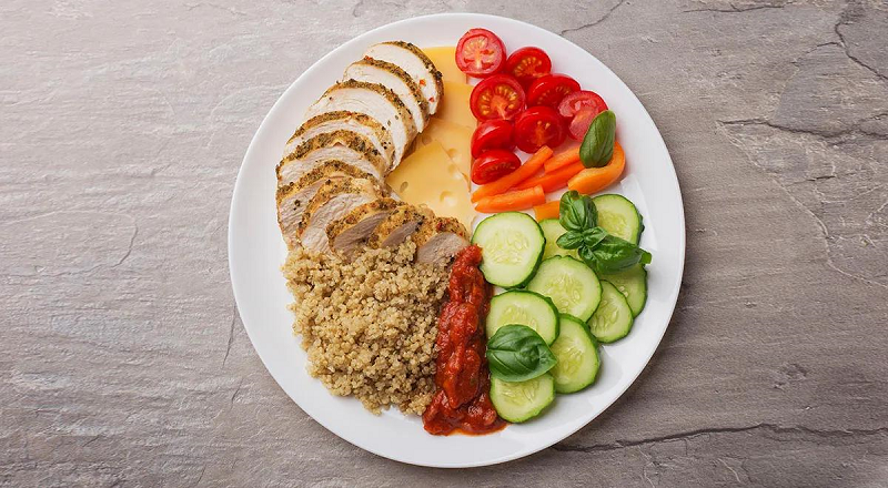 Balanced healthy plate with vegetables, fruits, whole grains, and lean protein